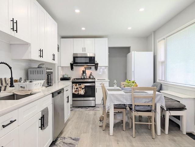 18 Victory St, Bridgeport, CT 06606 - kitchen featuring appliances with stainless steel finishes, backsplash, light countertops, recessed lighting, and white cabinets
