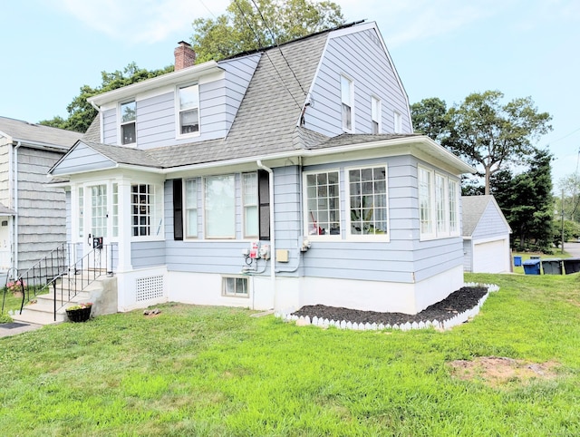 18 Victory St, Bridgeport, CT 06606 - view of front facade featuring a chimney, a front yard, a gambrel roof, a detached garage, and roof with shingles