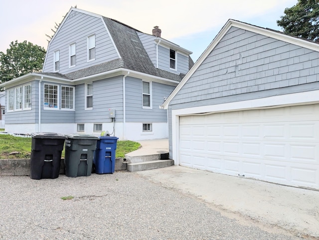 18 Victory St, Bridgeport, CT 06606 - view of side of home with roof with shingles, a gambrel roof, a chimney, and a garage