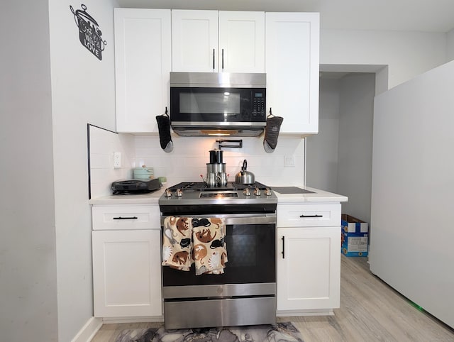 18 Victory St, Bridgeport, CT 06606 - kitchen featuring stainless steel appliances, tasteful backsplash, light countertops, light wood-style floors, and white cabinetry