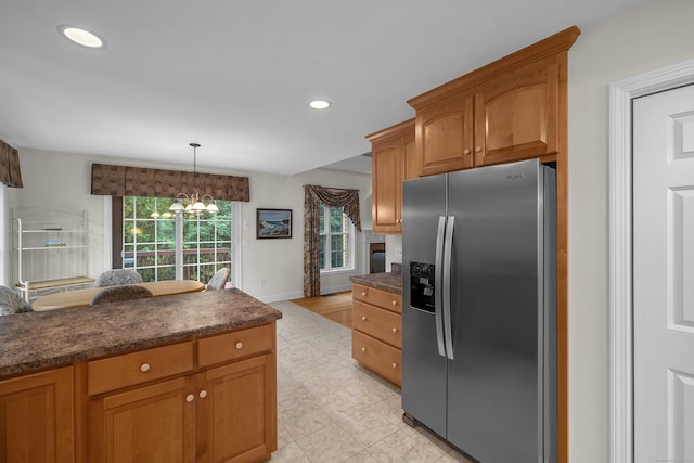 16 Spinnaker Dr Unit 16, East Lyme, CT 06357 - kitchen with stainless steel fridge with ice dispenser, dark countertops, recessed lighting, brown cabinets, and hanging light fixtures