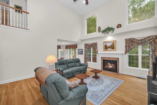 16 Spinnaker Dr Unit 16, East Lyme, CT 06357 - living room featuring a ceiling fan, wood finished floors, high vaulted ceiling, a tile fireplace, and plenty of natural light