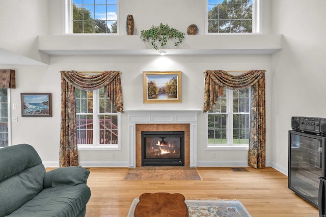 16 Spinnaker Dr Unit 16, East Lyme, CT 06357 - living room with beverage cooler, wood finished floors, a fireplace, a towering ceiling, and plenty of natural light