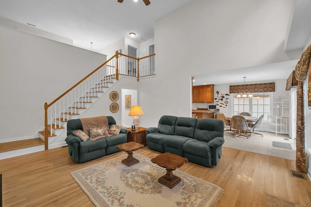 16 Spinnaker Dr Unit 16, East Lyme, CT 06357 - living room with stairs, light wood-type flooring, ceiling fan, a towering ceiling, and a chandelier