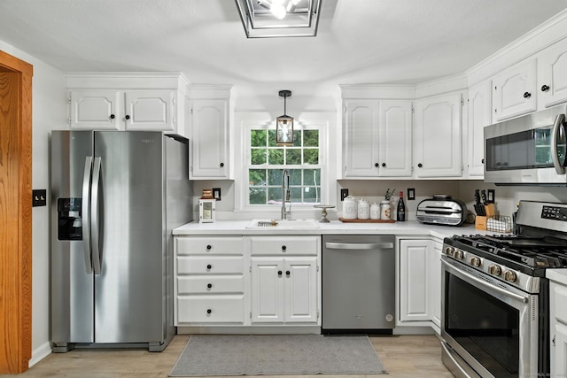 17 Wilstar Cir, Enfield, CT 06082 - kitchen featuring stainless steel appliances, light wood-type flooring, white cabinetry, light countertops, and decorative light fixtures