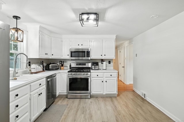 17 Wilstar Cir, Enfield, CT 06082 - kitchen with appliances with stainless steel finishes, light wood-style flooring, white cabinetry, and light countertops