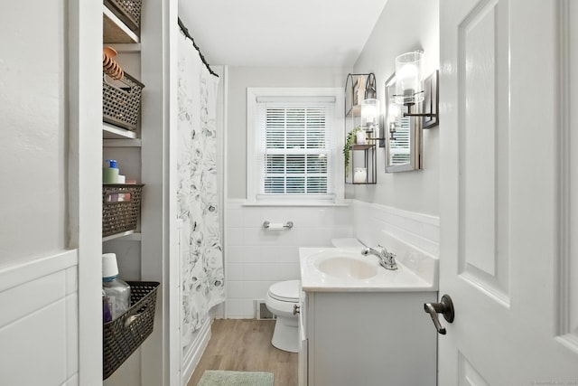17 Wilstar Cir, Enfield, CT 06082 - full bath featuring vanity, wood finished floors, wainscoting, tile walls, and a shower with shower curtain