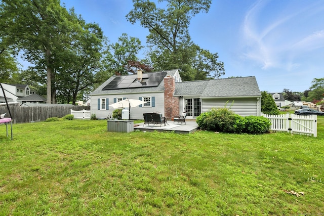 17 Wilstar Cir, Enfield, CT 06082 - rear view of property featuring solar panels, a fenced backyard, a trampoline, and roof with shingles