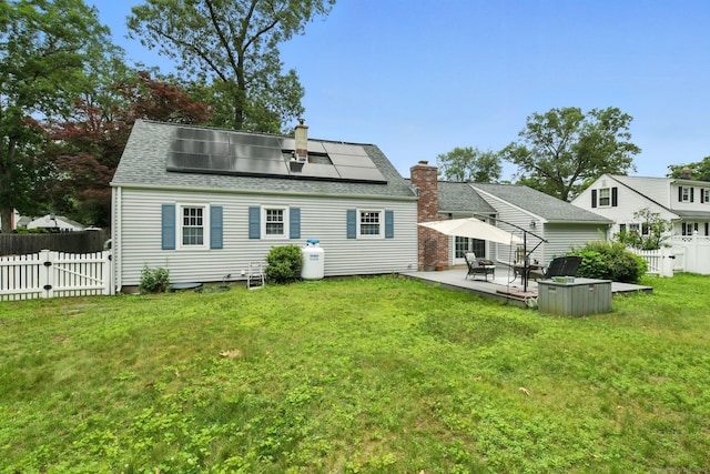 17 Wilstar Cir, Enfield, CT 06082 - rear view of house with a chimney, solar panels, a fenced backyard, a patio, and a shingled roof