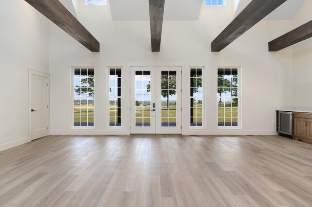 30 Tyrone Rd, Pomfret, CT 06259 - unfurnished living room with beverage cooler, beam ceiling, high vaulted ceiling, light wood-style floors, and plenty of natural light