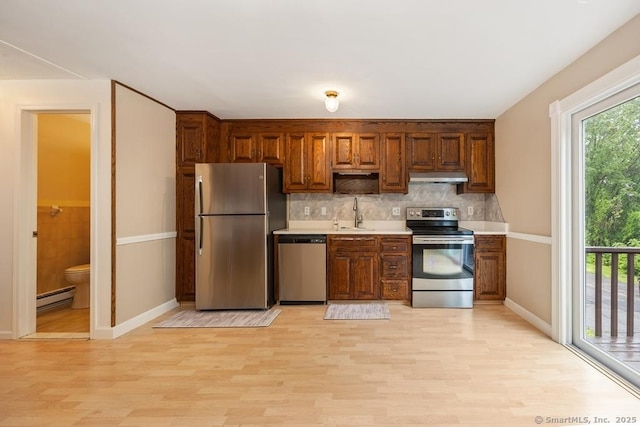 241 Judith Ln Unit 2, Waterbury, CT 06704 - kitchen featuring stainless steel appliances, baseboard heating, light wood-style floors, light countertops, and under cabinet range hood