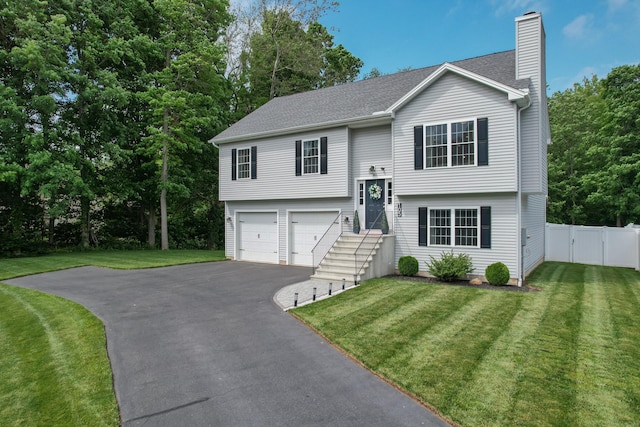 105 Hidden Pines Cir, Meriden, CT 06451 - raised ranch featuring a chimney, asphalt driveway, an attached garage, a gate, and roof with shingles