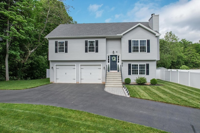 105 Hidden Pines Cir, Meriden, CT 06451 - bi-level home with driveway, a chimney, an attached garage, and roof with shingles