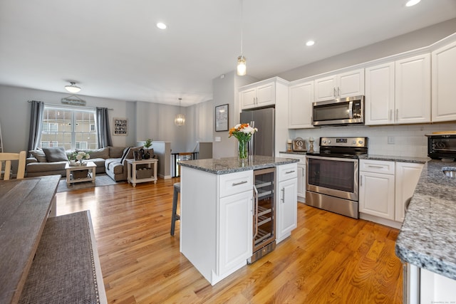 105 Hidden Pines Cir, Meriden, CT 06451 - kitchen featuring appliances with stainless steel finishes, white cabinetry, wine cooler, decorative backsplash, and recessed lighting