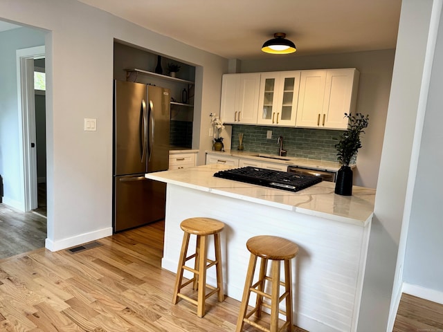 179 Mcgrath Ct, Stratford, CT 06615 - kitchen featuring freestanding refrigerator, a peninsula, light wood-style floors, and decorative backsplash