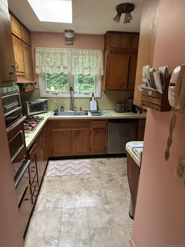 97 Flint Ridge Rd, Monroe, CT 06468 - kitchen with stainless steel appliances, light countertops, brown cabinetry, and a skylight