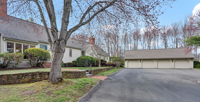 189 Redstone Hill Rd Unit 7, Bristol, CT 06010 - view of front of property with a chimney, a garage, an outbuilding, roof with shingles, and a front lawn
