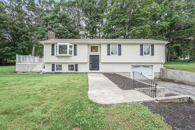 471 Moosup Pond Rd, Plainfield, CT 06354 - raised ranch with concrete driveway, an attached garage, a chimney, a front lawn, and a wooden deck
