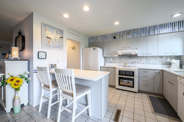 143 Sandy Point Rd Unit 143, Old Saybrook, CT 06475 - kitchen featuring white appliances, under cabinet range hood, light tile patterned floors, gray cabinetry, and recessed lighting