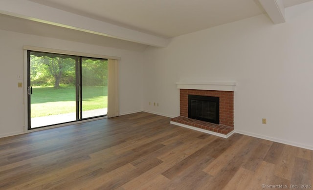 648 Heritage Vlg Unit A, Southbury, CT 06488 - unfurnished living room featuring beamed ceiling, wood finished floors, and a brick fireplace