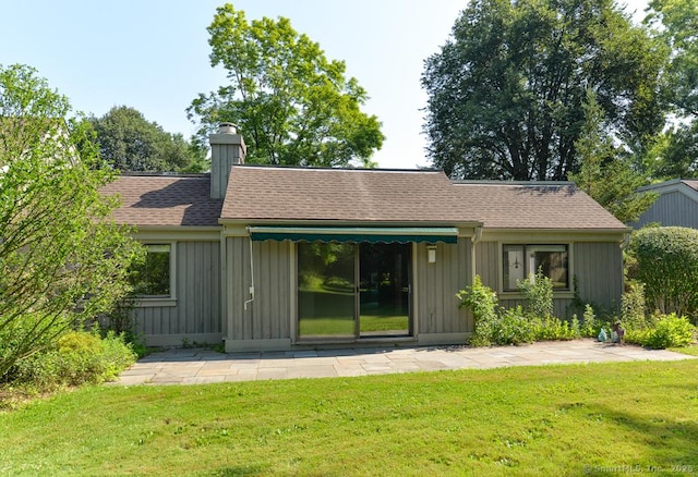 648 Heritage Vlg Unit A, Southbury, CT 06488 - back of house with a chimney, board and batten siding, a lawn, and roof with shingles