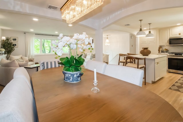 59 Flint Ridge Rd, Monroe, CT 06468 - dining area featuring arched walkways, light wood finished floors, recessed lighting, and a chandelier