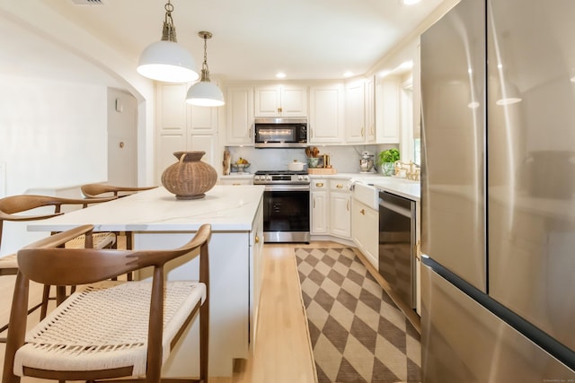 59 Flint Ridge Rd, Monroe, CT 06468 - kitchen featuring appliances with stainless steel finishes, white cabinetry, pendant lighting, recessed lighting, and light wood-type flooring