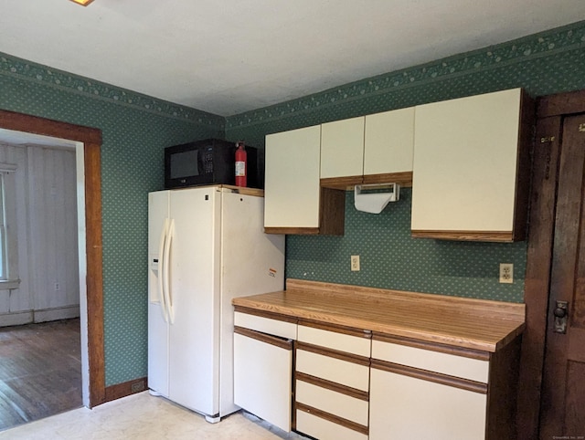 10 Staples St, Danbury, CT 06810 - kitchen with white refrigerator with ice dispenser, wallpapered walls, light countertops, black microwave, and white cabinetry