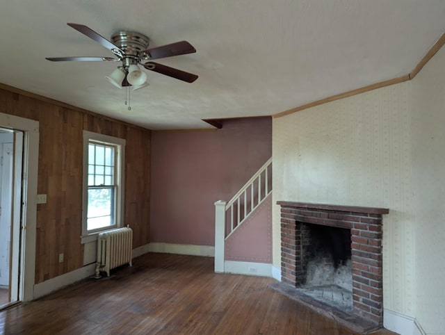 10 Staples St, Danbury, CT 06810 - unfurnished living room featuring radiator heating unit, wood finished floors, a ceiling fan, stairs, and wooden walls