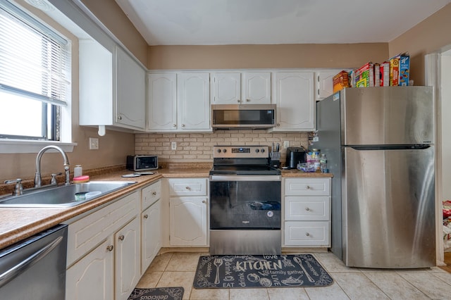 560 Yale Ave Unit 209, Meriden, CT 06450 - kitchen with stainless steel appliances, white cabinetry, light tile patterned floors, backsplash, and light countertops