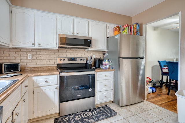 560 Yale Ave Unit 209, Meriden, CT 06450 - kitchen featuring stainless steel appliances, white cabinetry, backsplash, and light tile patterned floors