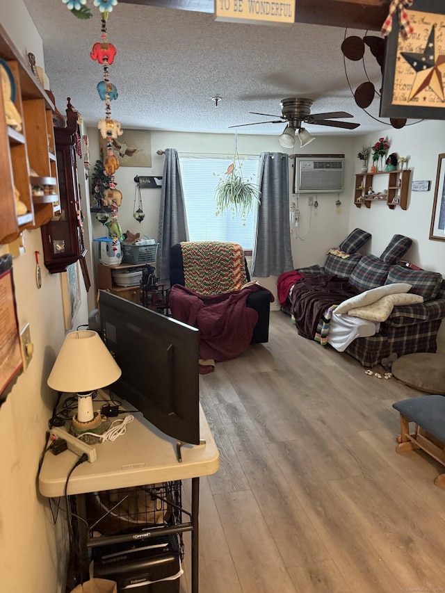 531 Meriden Rd Unit 2, Waterbury, CT 06705 - living area featuring a wall mounted AC, wood finished floors, a textured ceiling, and a ceiling fan