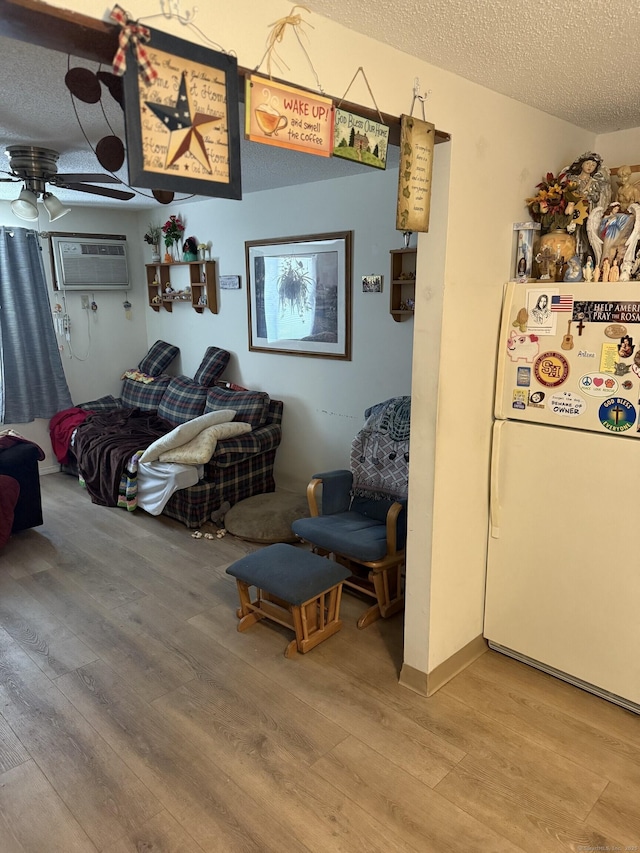 531 Meriden Rd Unit 2, Waterbury, CT 06705 - bedroom featuring freestanding refrigerator, light wood finished floors, a textured ceiling, and a wall unit AC