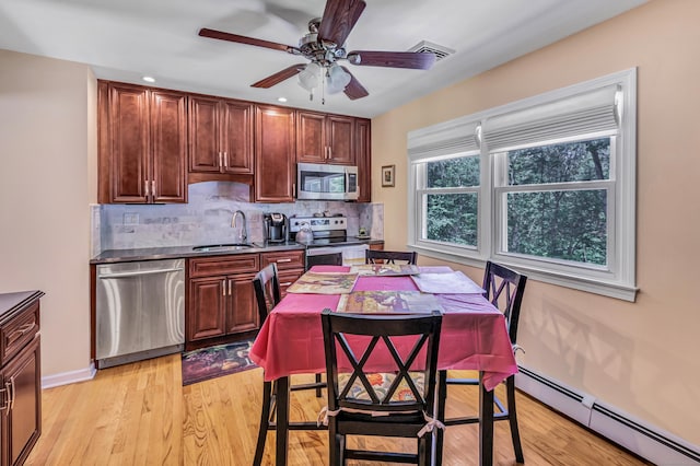 59 Laurel Wood Dr, Shelton, CT 06484 - kitchen with appliances with stainless steel finishes, baseboard heating, backsplash, ceiling fan, and light wood finished floors