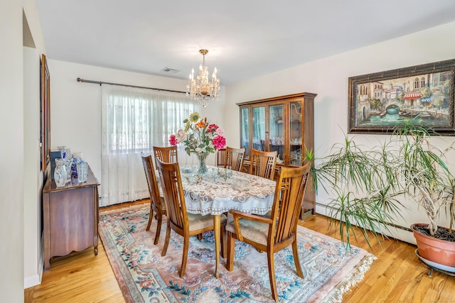 59 Laurel Wood Dr, Shelton, CT 06484 - dining area with a chandelier and light wood-style flooring