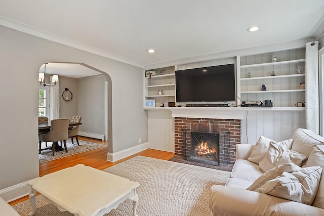 8 Gillies Ln, Norwalk, CT 06854 - living area with arched walkways, wood finished floors, a baseboard heating unit, crown molding, and recessed lighting