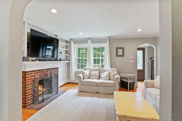 8 Gillies Ln, Norwalk, CT 06854 - living area with arched walkways, plenty of natural light, a brick fireplace, wood finished floors, and ornamental molding