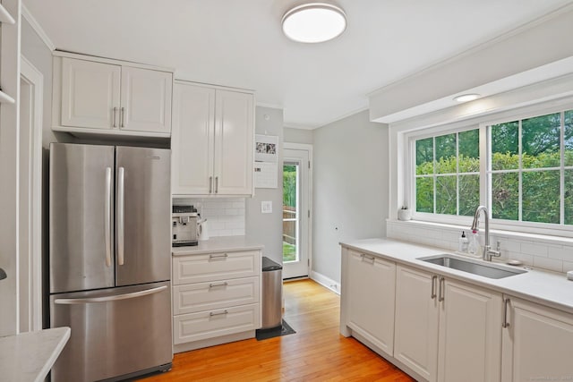 8 Gillies Ln, Norwalk, CT 06854 - kitchen featuring freestanding refrigerator, decorative backsplash, light countertops, white cabinets, and crown molding