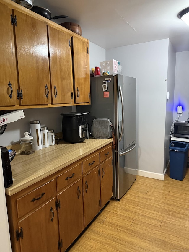 32 S St, Norwalk, CT 06854 - kitchen with light wood-type flooring, light countertops, stainless steel appliances, and brown cabinetry