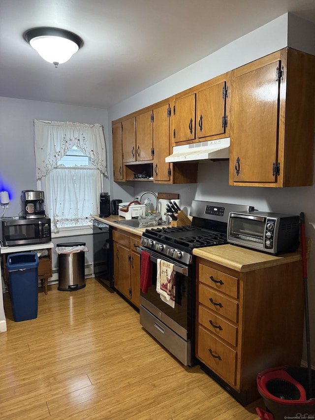 32 S St, Norwalk, CT 06854 - kitchen featuring stainless steel range with gas cooktop, black dishwasher, under cabinet range hood, brown cabinets, and light wood-style floors