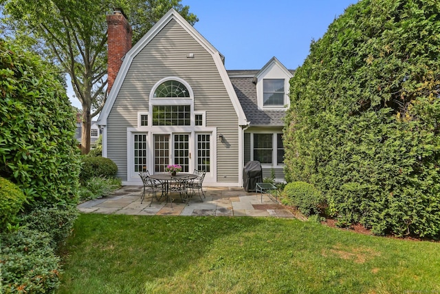 21 Lakeview Ave Unit 21, New Canaan, CT 06840 - rear view of house featuring a patio area, a yard, a gambrel roof, a chimney, and roof with shingles