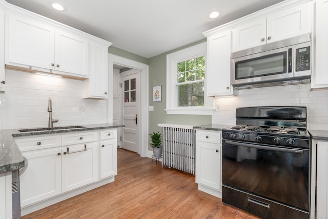 27 Thornton St, Hamden, CT 06517 - kitchen with black range with gas stovetop, stainless steel microwave, white cabinets, light wood-style flooring, and recessed lighting