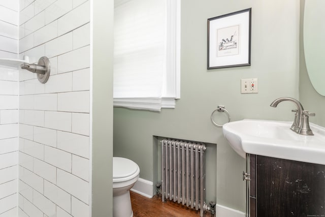 27 Thornton St, Hamden, CT 06517 - bathroom with radiator heating unit, a tile shower, vanity, and wood finished floors