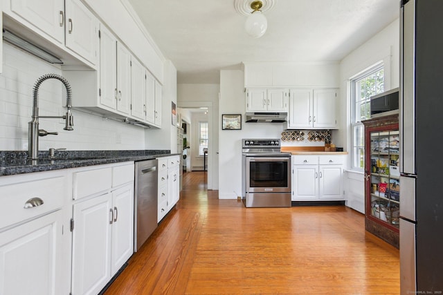 24 Warren Ave, Groton, CT 06355 - kitchen featuring stainless steel appliances, under cabinet range hood, decorative backsplash, and white cabinetry