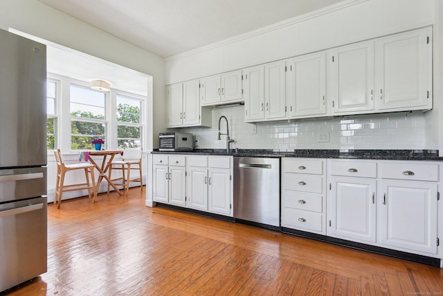 24 Warren Ave, Groton, CT 06355 - kitchen with appliances with stainless steel finishes, decorative backsplash, white cabinets, and ornamental molding