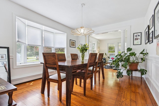 24 Warren Ave, Groton, CT 06355 - dining room with hardwood / wood-style flooring, decorative columns, and a chandelier