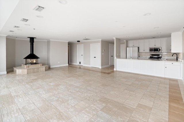 104 N St Apt 803, Stamford, CT 06902 - unfurnished living room featuring ornamental molding, recessed lighting, and a wood stove
