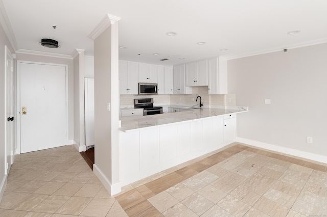104 N St Apt 803, Stamford, CT 06902 - kitchen featuring appliances with stainless steel finishes, a peninsula, crown molding, tasteful backsplash, and white cabinets
