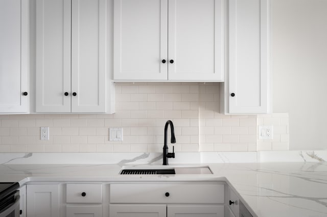 104 N St Apt 803, Stamford, CT 06902 - kitchen with white cabinets, decorative backsplash, stainless steel electric stove, and light stone countertops