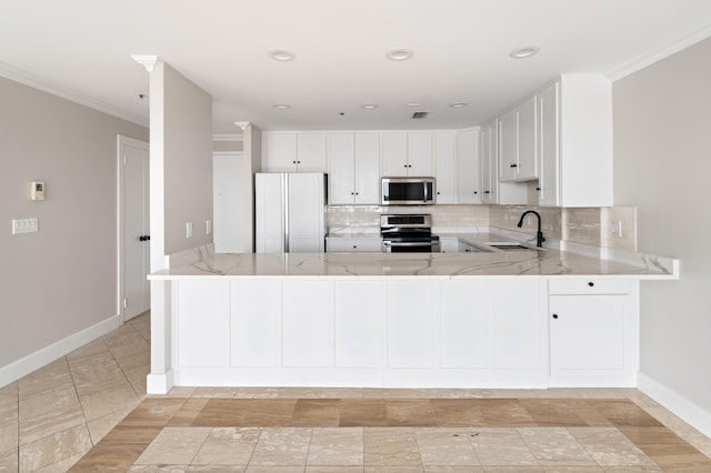 104 N St Apt 803, Stamford, CT 06902 - kitchen featuring stainless steel appliances, light stone countertops, a peninsula, decorative backsplash, and ornamental molding
